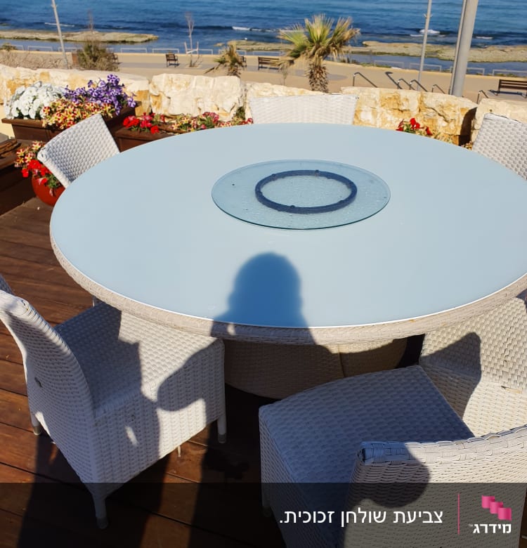 צלחת זכוכית עגולה על שולחן עגול בחוץ